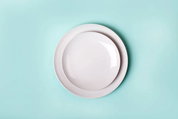 ceramics plate isolated on turquoise background - top view