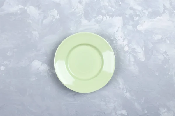 Empty green  plate  above over gray texture background. — Stock Photo, Image