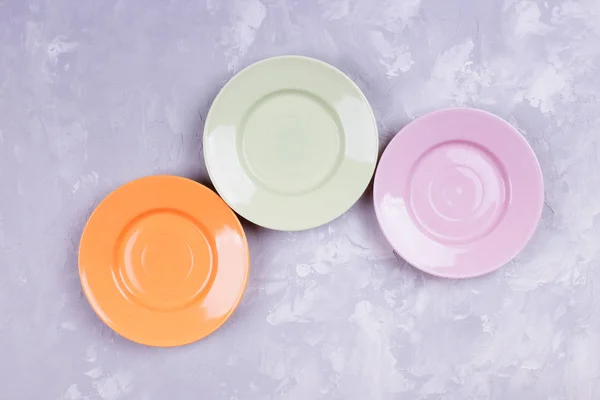 Different multicolored empty plates on a table, Set of plates. T