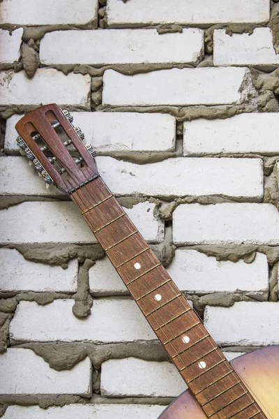 Akustik gitar sap kafası beyaz duvara karşı
