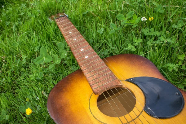 Cerca de la vieja guitarra acústica de madera en la hierba — Foto de Stock