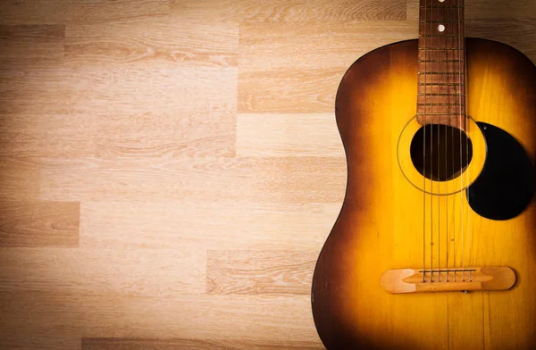 Guitarra acústica apoyada sobre un fondo grunge en blanco — Foto de Stock