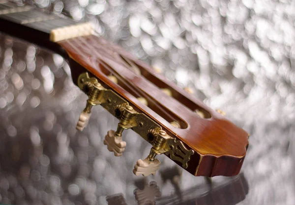 Cabeza de guitarra sobre fondo plateado — Foto de Stock