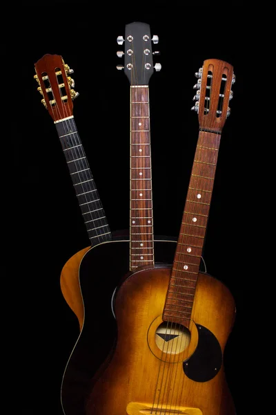 Tres guitarras acústicas sobre fondo negro — Foto de Stock