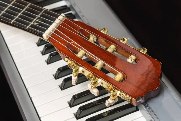 Cabezal de guitarra en el teclado del piano — Foto de Stock