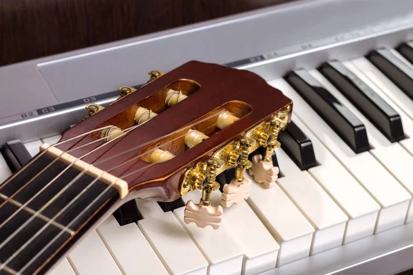 Cabeçalho da guitarra no teclado do piano — Fotografia de Stock