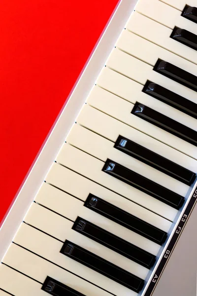 Teclado de piano digital en bacground rojo — Foto de Stock