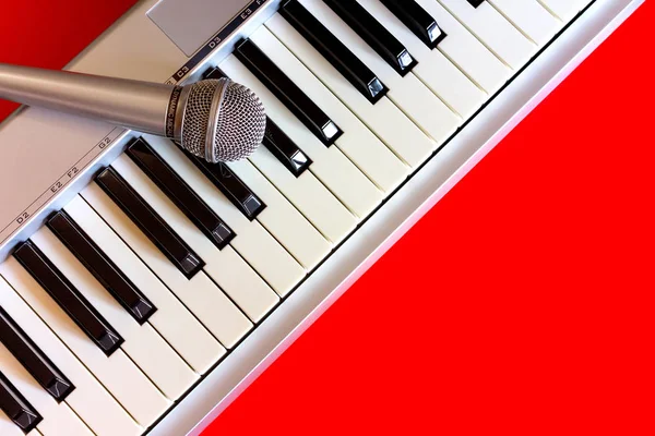 Piano digital con micrófono en bacground rojo — Foto de Stock
