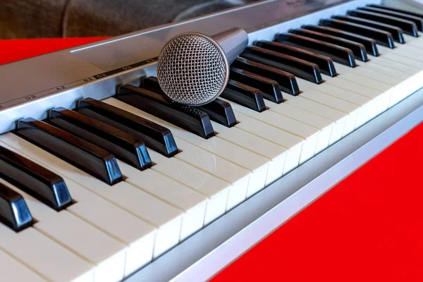 Teclado de piano digital com microfone em vermelho bacground — Fotografia de Stock