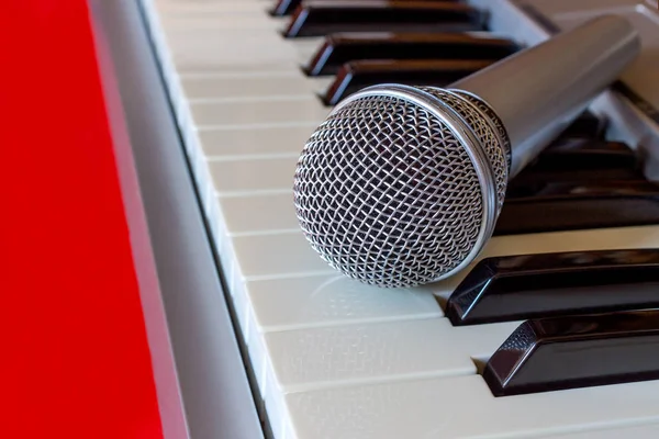Teclado de piano digital com microfone em vermelho bacground — Fotografia de Stock