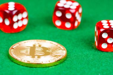 bitcoin metal madeni para ile yeşil kumaş üzerine kırmızı dices