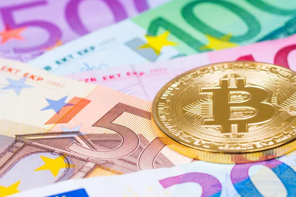 Moneda metálica de oro bitcoin sobre billetes en euros, financi futuro — Foto de Stock