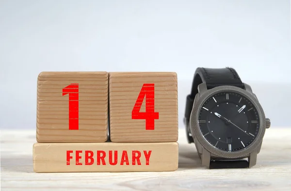 14 february, calendar on wooden blocks with wrist watch — Stock Photo, Image