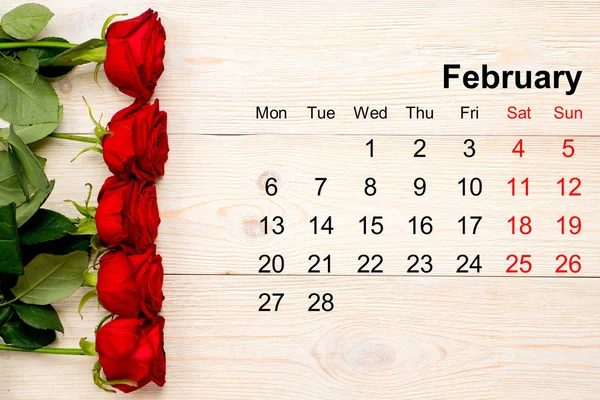 Calendario febbraio 2017 con rose rosse sul tavolo bianco — Foto Stock