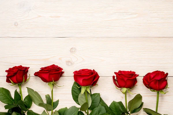 5 rosas vermelhas na fileira em mesas rústicas brancas — Fotografia de Stock