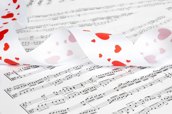 white ribbon with red hearts on music notes
