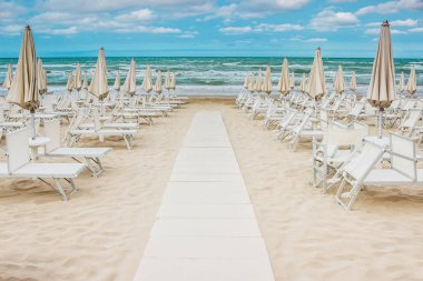 Satır kapalı şemsiye ve şezlonglar boş sahilde