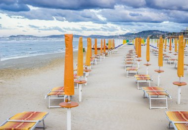 Satır kapalı şemsiye ve şezlonglar boş sahilde