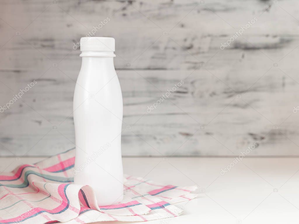 White blank plastic bottle with screw cap on kitchen table