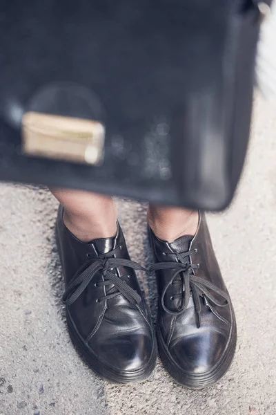 Женские ноги в черных ботинках на улице — стоковое фото