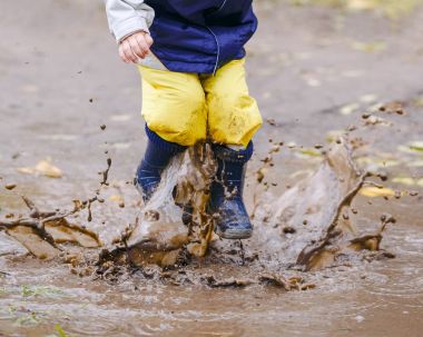 Mutlu çocuk kauçuk göletlerde atlama botlar