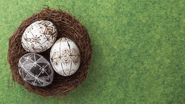 Velikonoční vajíčka v hnízdě na zeleném pozadí — Stock fotografie