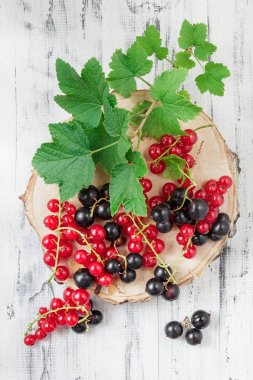 Redcurrants ve blackcurrants Beyaz ahşap zemin üzerinde