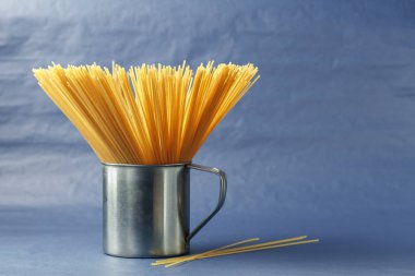 Pişmemiş makarna spagetti mor bir arka plan üzerinde