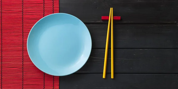 Άδειο πιάτο και chopsticks σε σκούρο φόντο — Φωτογραφία Αρχείου