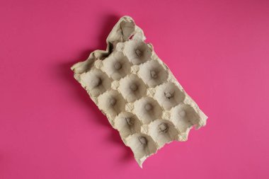 Parlak pembe arkaplanda boş kağıt yumurta tepsisi