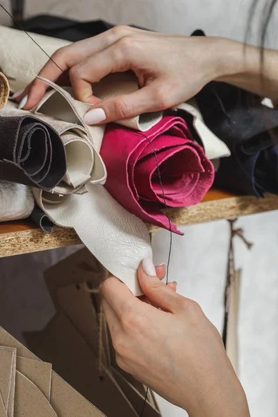 Woman choosing fabric in sewing workshop studio