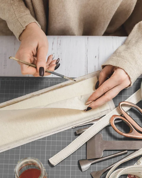 Frauenhände gestalten Lederhandtasche in einer Werkstatt — Stockfoto