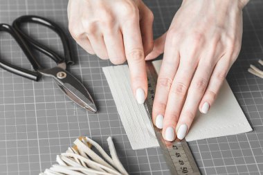 Bir atölyede deri kesen bir kadın.