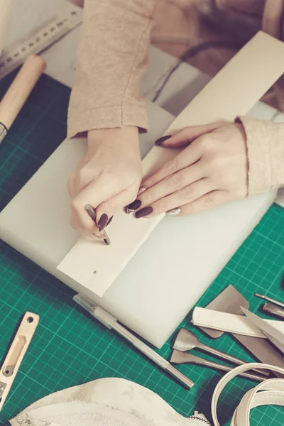 Frauenhände gestalten Lederhandtasche in einer Werkstatt — Stockfoto