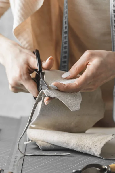 Frau misst und schneidet Leder in einer Werkstatt — Stockfoto