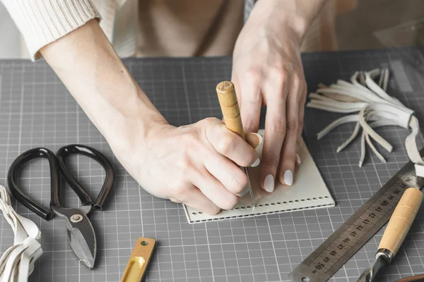 Frau misst und schneidet Leder in einer Werkstatt — Stockfoto