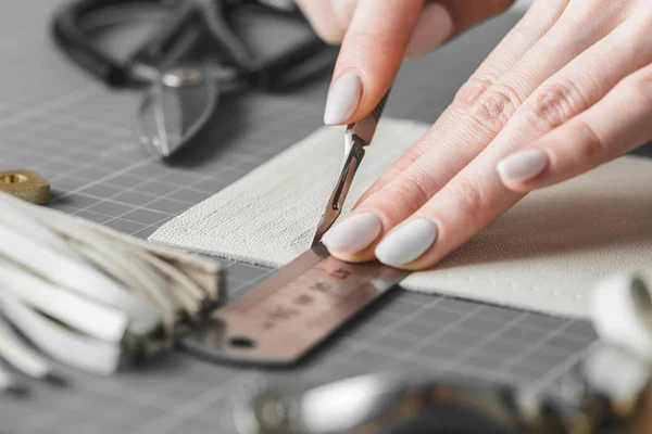 Vrouw meten en snijden van leer in een werkplaats — Stockfoto