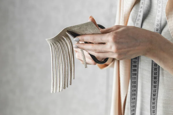 Женщина режет кожаный бахрому для деталей сумочки — стоковое фото