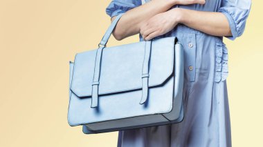 Açık mavi kurye çantası taşıyan bir kadın.