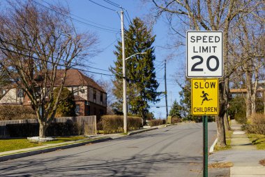 Amerikan Mahallesi 'nde okul ya da anaokulu yakınlarında hız limitini 20 mil olarak gösteren yol işareti var.