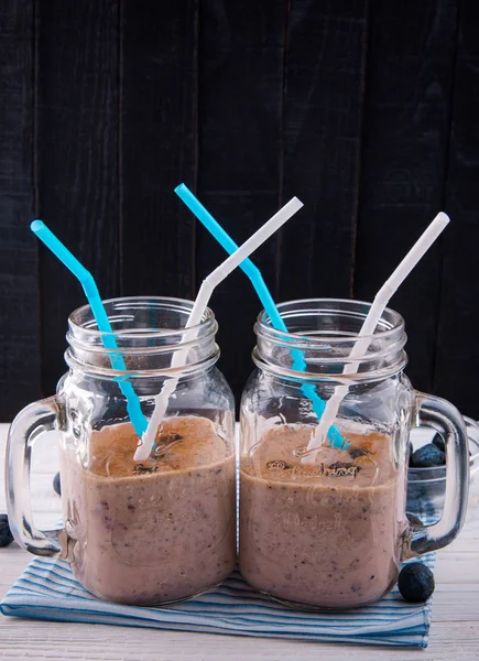 Smoothies Blackberry en bouteilles de verre sur table en bois — Photo