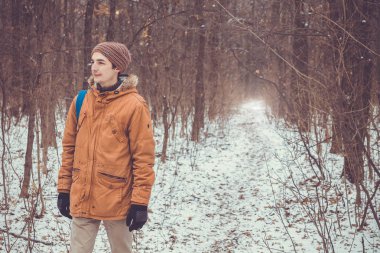 Kış ormanda yürüyen adam.