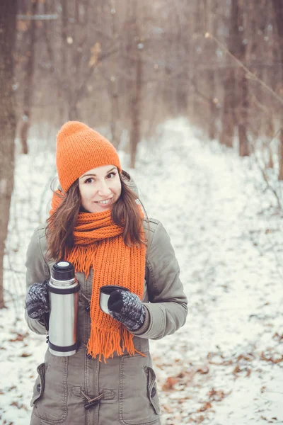 Leende ung tjej dricker te i vinter skog — Stockfoto