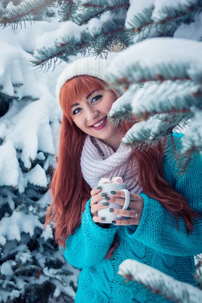 Mujer sostiene taza de café con malvavisco en el bosque de invierno — Foto de Stock