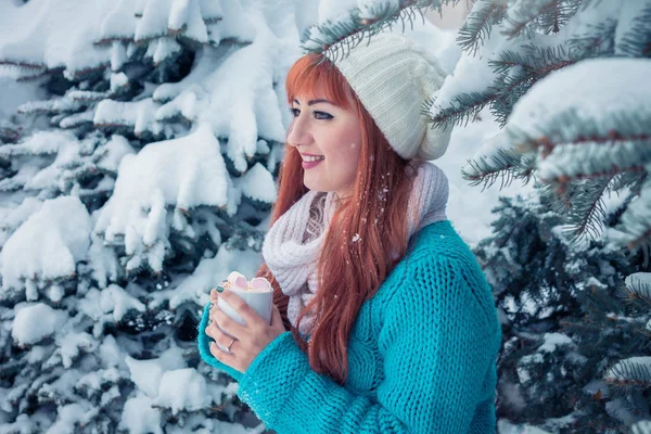 Mujer sostiene taza de café con malvavisco en el bosque de invierno — Foto de Stock