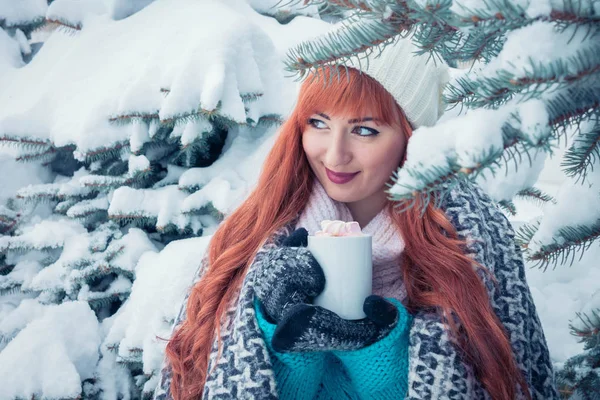 Mujer sostiene taza de café con malvavisco en el bosque de invierno — Foto de Stock