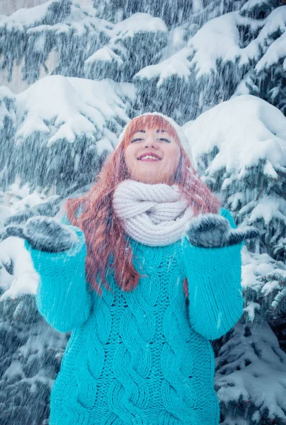 Young woman throws snow