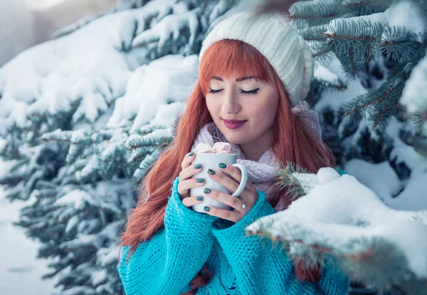 Mujer sostiene taza de café con malvavisco en el bosque de invierno — Foto de Stock