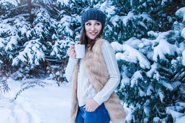 Mujer sostiene taza de café con malvavisco en el bosque de invierno — Foto de Stock