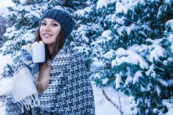 Mujer sostiene taza de café con malvavisco en el bosque de invierno — Foto de Stock